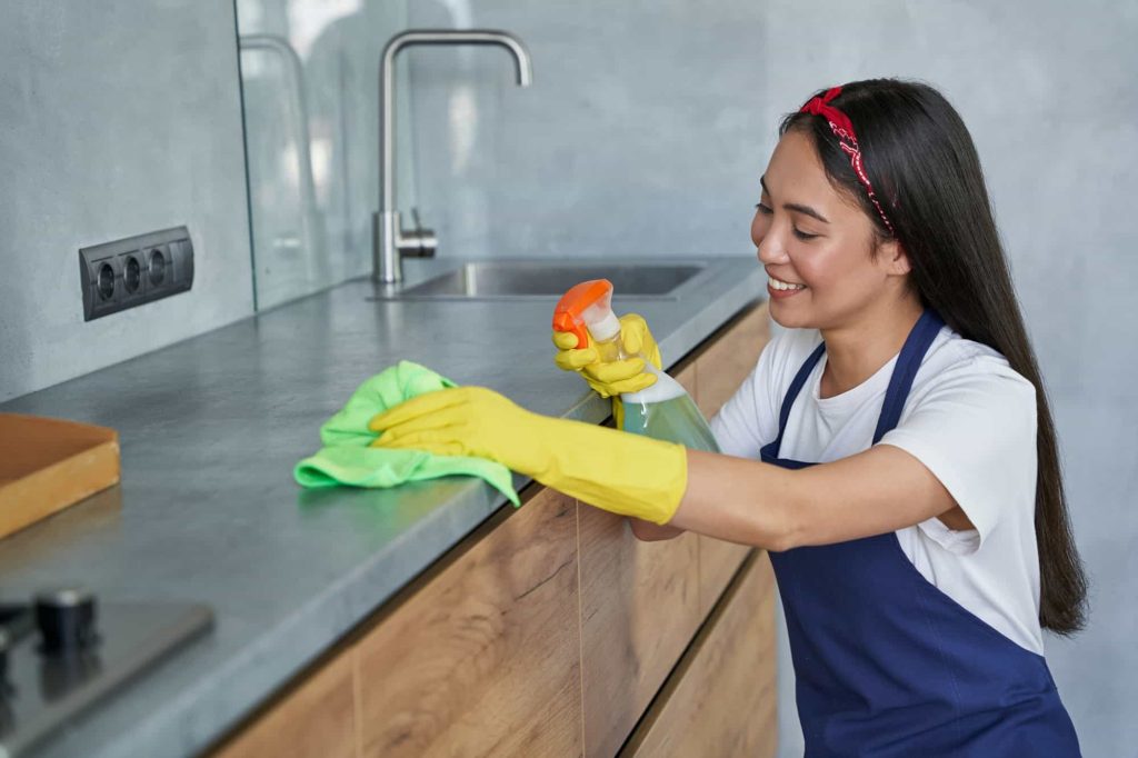 Young Women Cleaning Lady Smiling while Cleaning the Kitchen