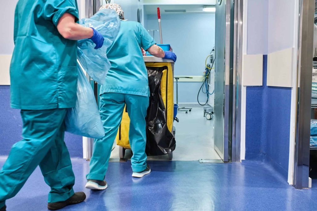 Hospital Cleaning Staff enter an Operating Room with a Cleaning Cart