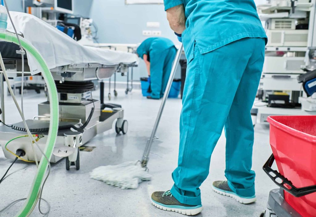 Women Cleaning Staff Mopping the Floor of Hospital Operating Room