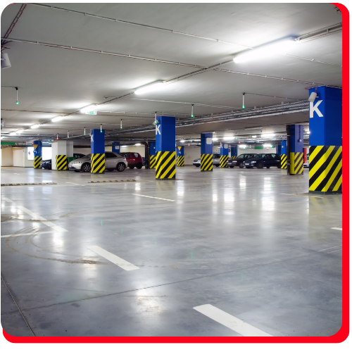 Polished epoxy flooring in a commercial underground parking garage with safety markings.
