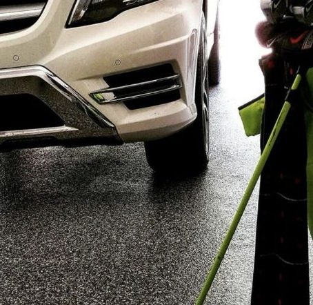 Epoxy-coated garage floor in Cambridge with a parked SUV and golf equipment in view.