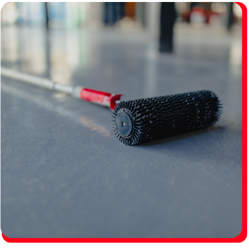 Close-up of a spiked epoxy roller resting on a smooth grey epoxy floor in Markham.