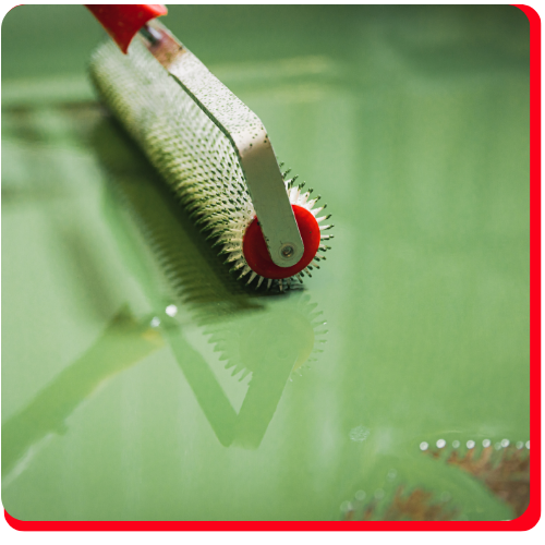 Close-up of a spike roller being used on a green epoxy floor in Muskoka.