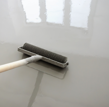 Epoxy roller applies smooth grey coating on a glossy floor in Richmond Hill.