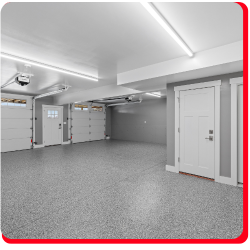 Clean residential garage with a speckled epoxy flake flooring system and bright overhead lighting.