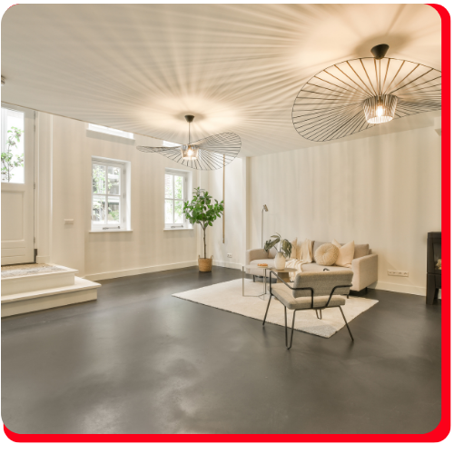 A stylish living room with sleek dark grey epoxy flooring and modern minimalist decor.
