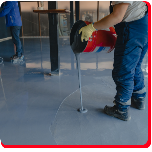 Gloved hand applying waterproof epoxy coating with a trowel in Aurora facility.