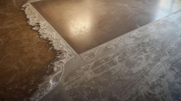 Close-up of concrete floor coating transition showing prepared surface and finished section.