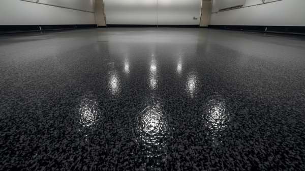 Glossy black epoxy garage floor with a speckled finish reflecting multiple overhead lights.