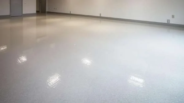 Light gray speckled epoxy floor in a commercial interior with reflected overhead lighting